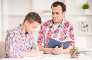 father helping his son to do homework.